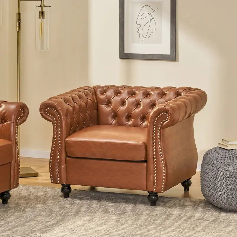 Fauteuil club capitonné en similicuir brun clair avec clous décoratifs et accoudoirs volutes
