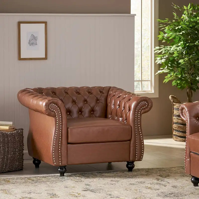 Fauteuil club capitonné en similicuir brun clair avec clous décoratifs et accoudoirs volutes