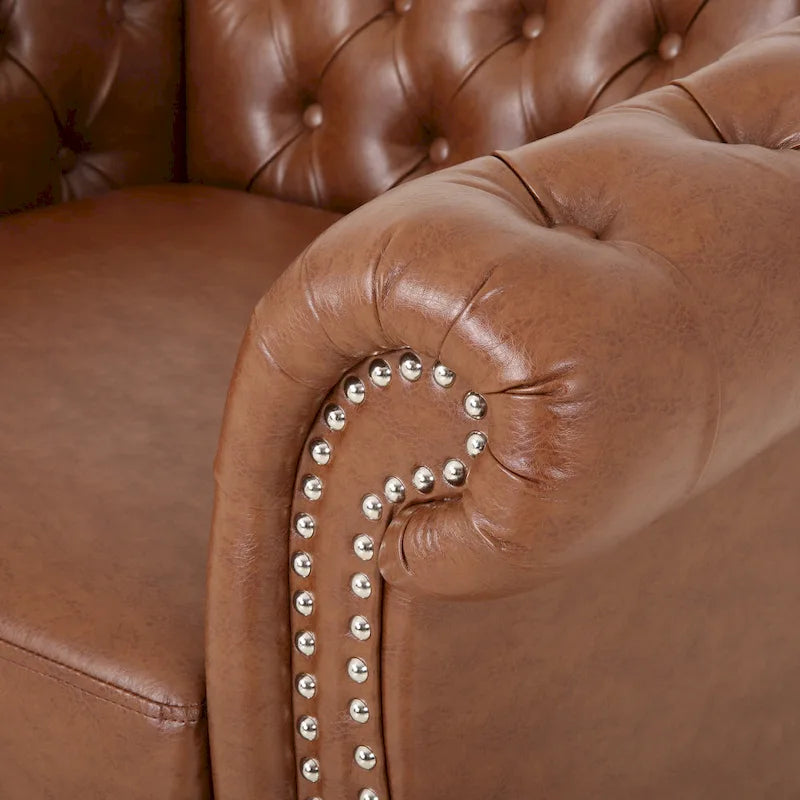 Fauteuil club capitonné en similicuir brun clair avec clous décoratifs et accoudoirs volutes