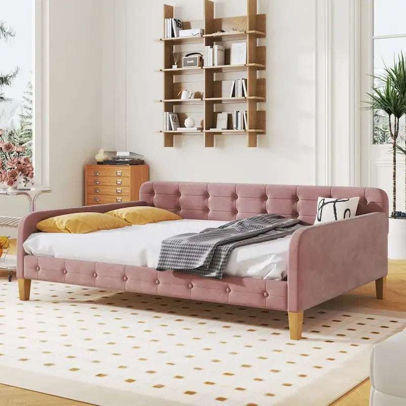 Canapé-lit capitonné en velours rose avec accoudoirs et pieds en bois