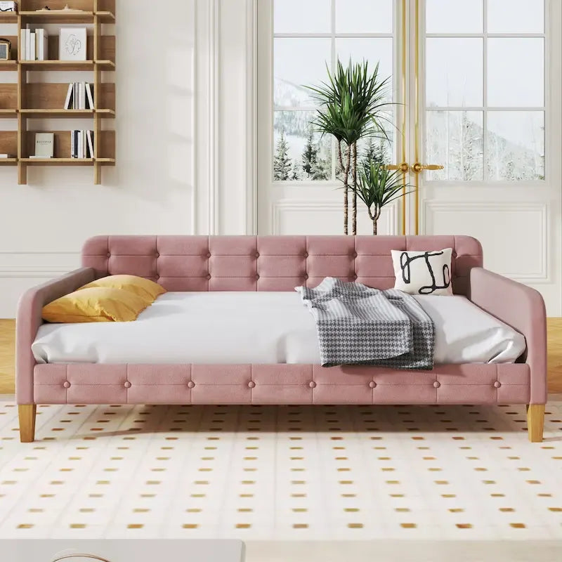 Canapé-lit capitonné en velours rose avec accoudoirs et pieds en bois