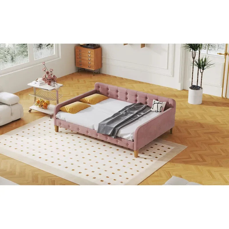 Canapé-lit capitonné en velours rose avec accoudoirs et pieds en bois